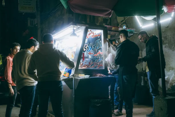 A vibrant street food stall scene in Cairo, Egypt, bustling with activity at night.