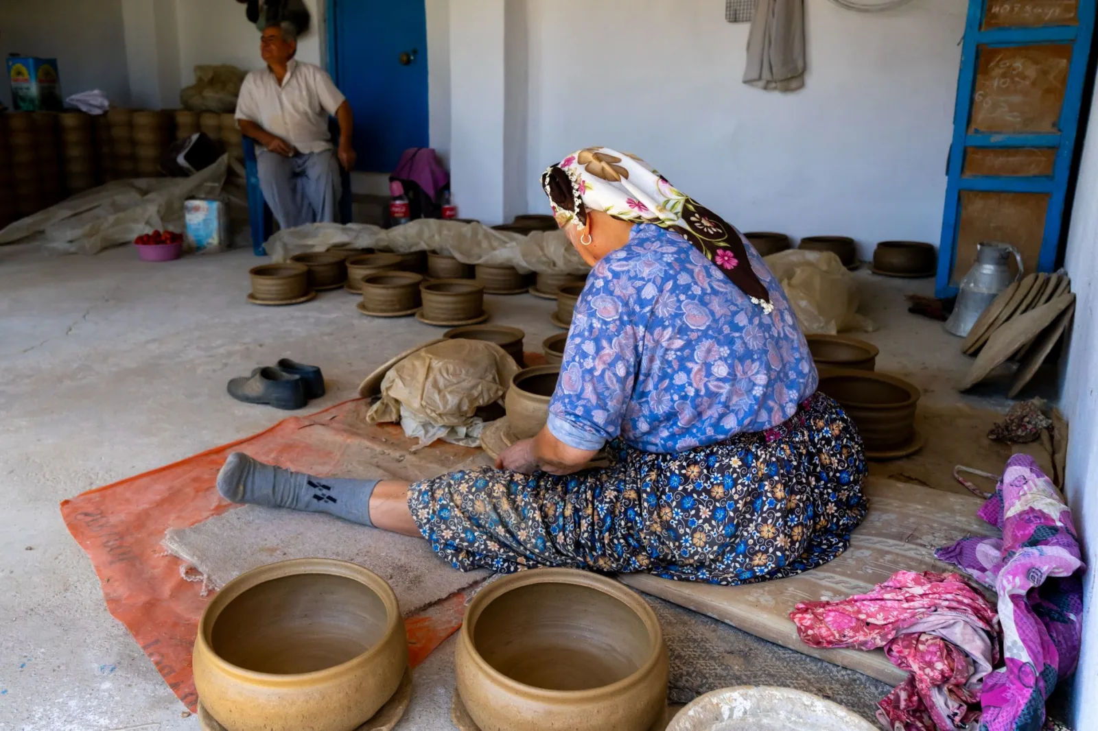 Elderly artisans crafting pottery in a traditional workshop, showcasing cultural craftsmanship.