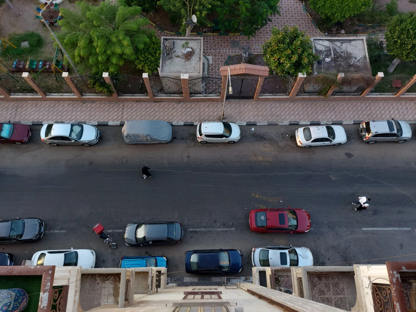 Aerial view of parked cars along a street in Port Said, Egypt, showcasing urban life.