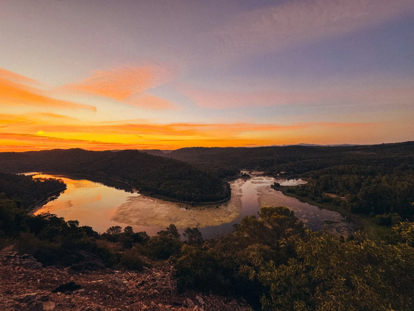 Breathtaking sunset view over a serene river and lush landscape in Carcès, France.