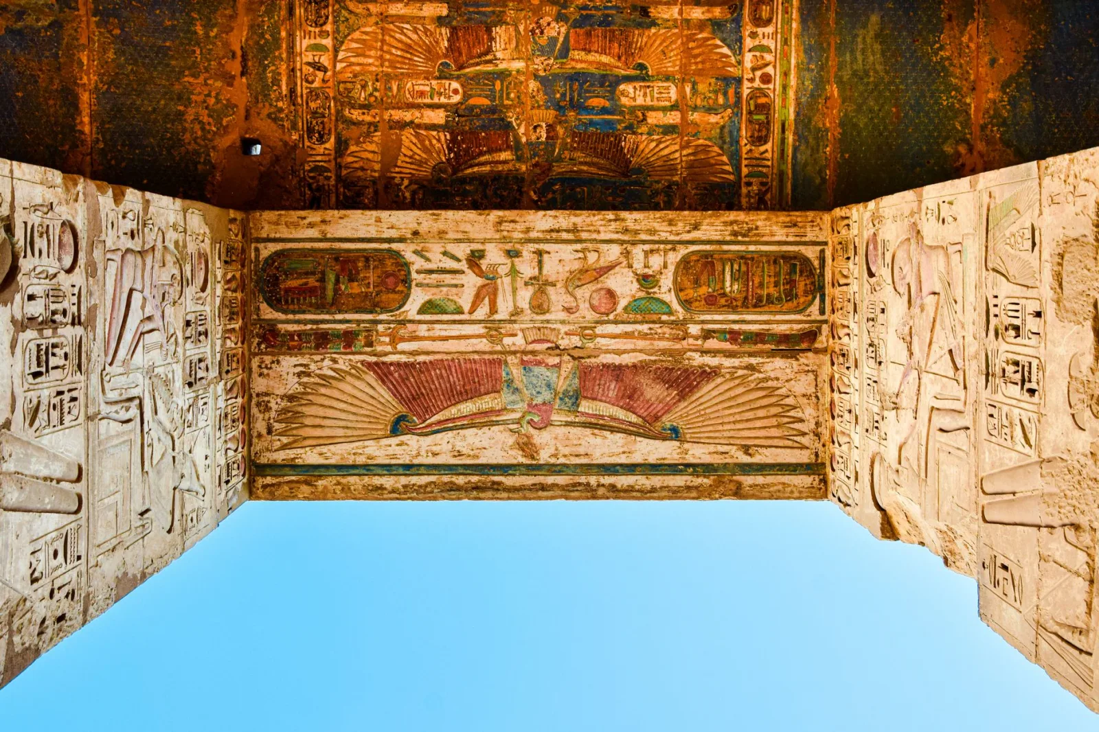 Vivid depiction of Egyptian hieroglyphs on a temple ceiling in Luxor, showcasing historic art.