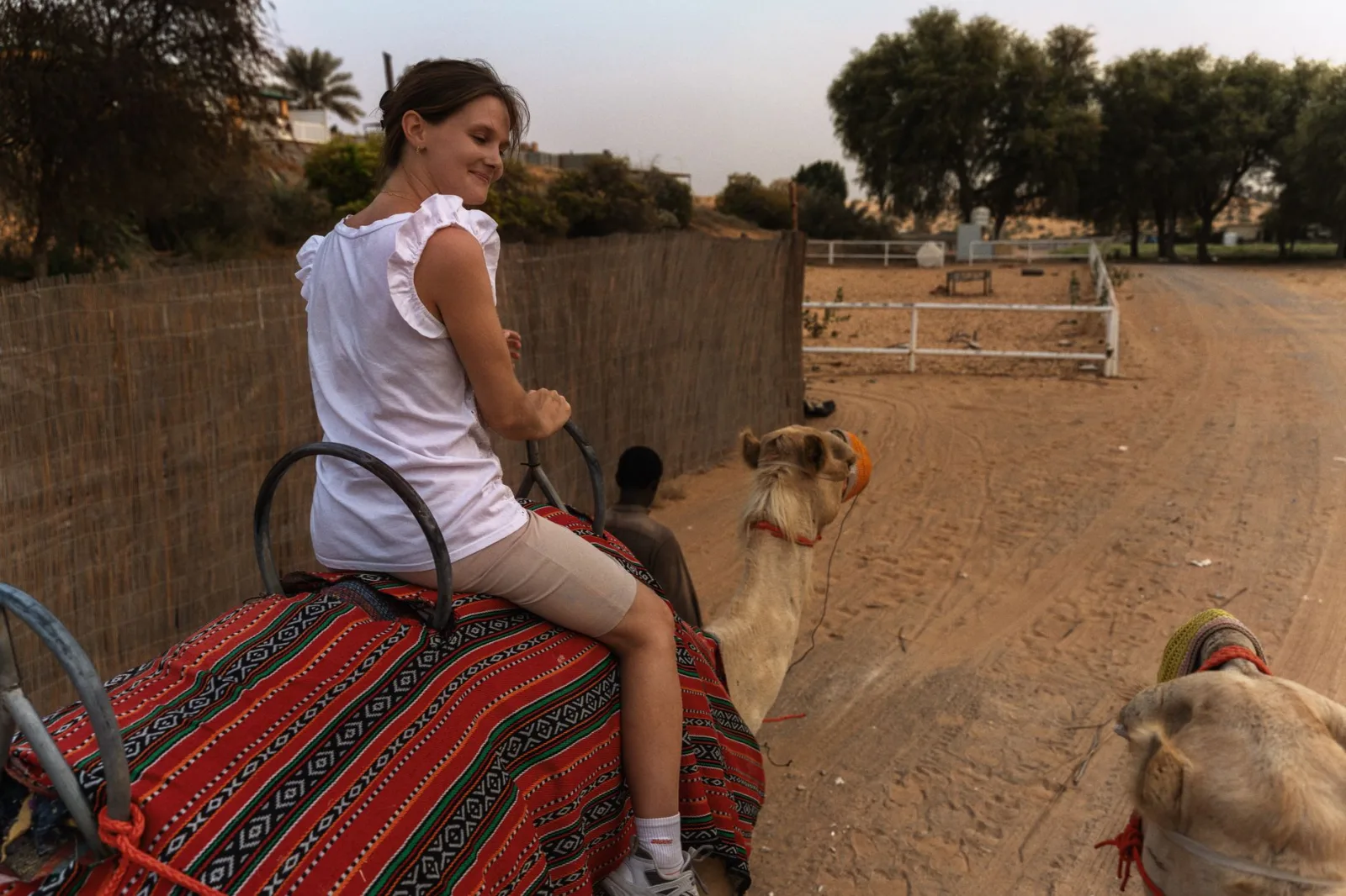 A woman enjoys a camel ride in the desert near Dubai, UAE.