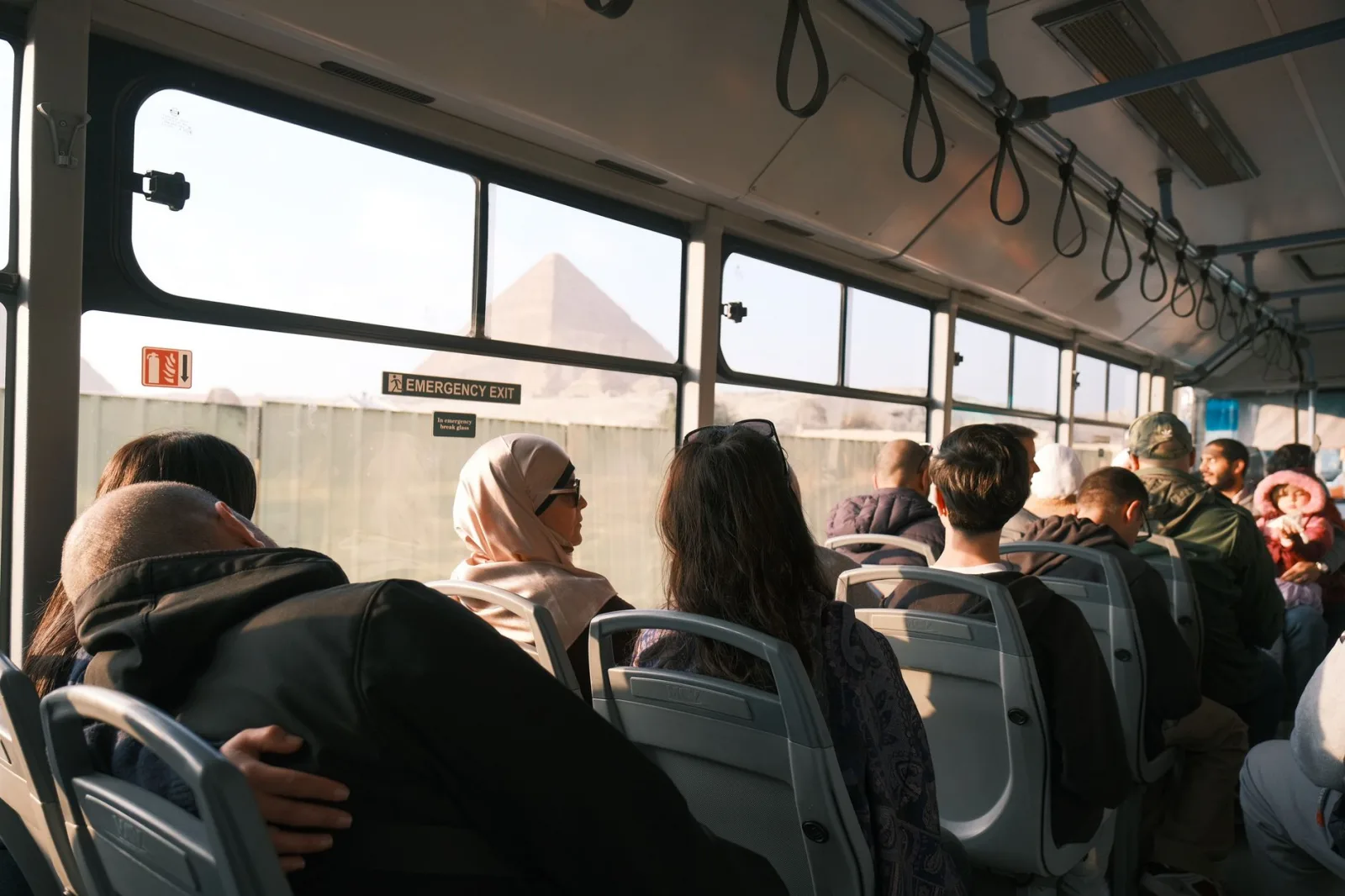 Passengers on a bus with a view of the Pyramid, capturing a moment in Cairo, Egypt.
