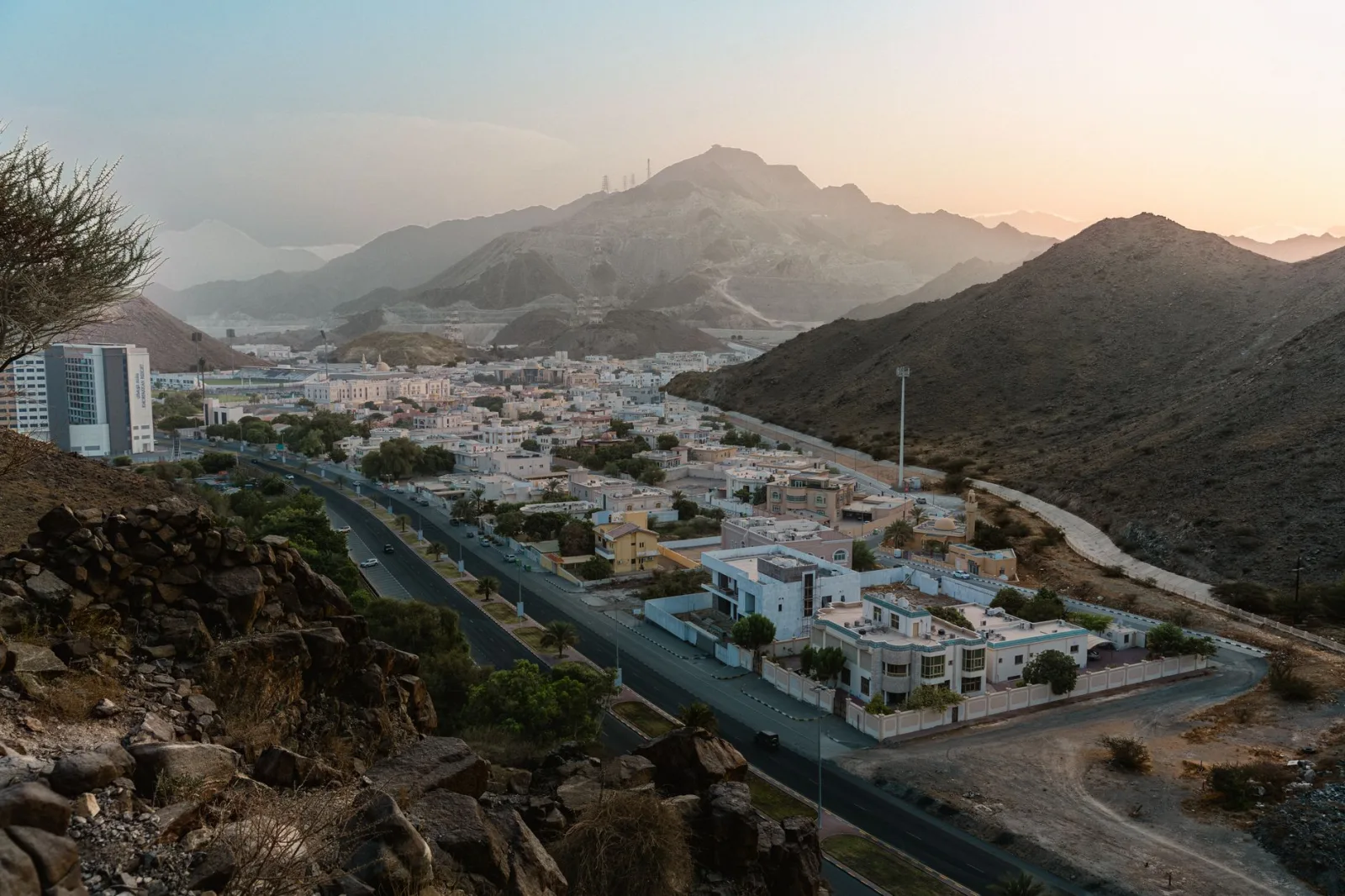 Discover the tranquil beauty of Khor Fakkan, UAE with this stunning aerial view at sunset.