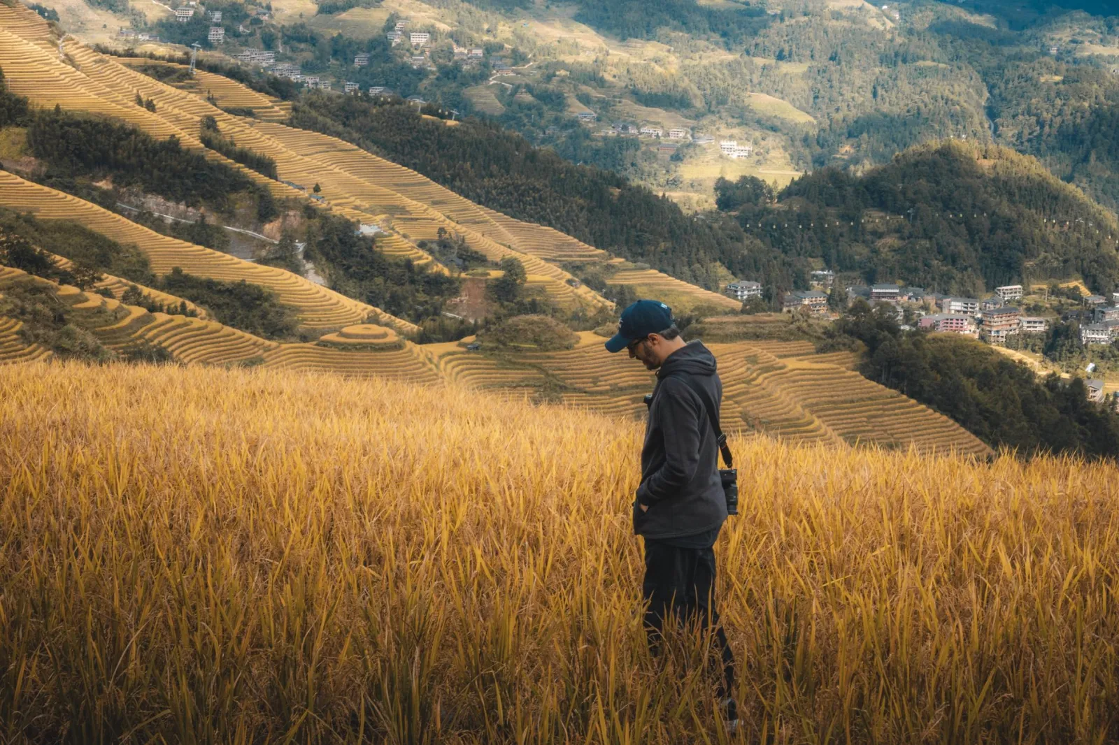 A person stands in a lush terraced field in Guilin, showcasing stunning landscapes and natural beauty.