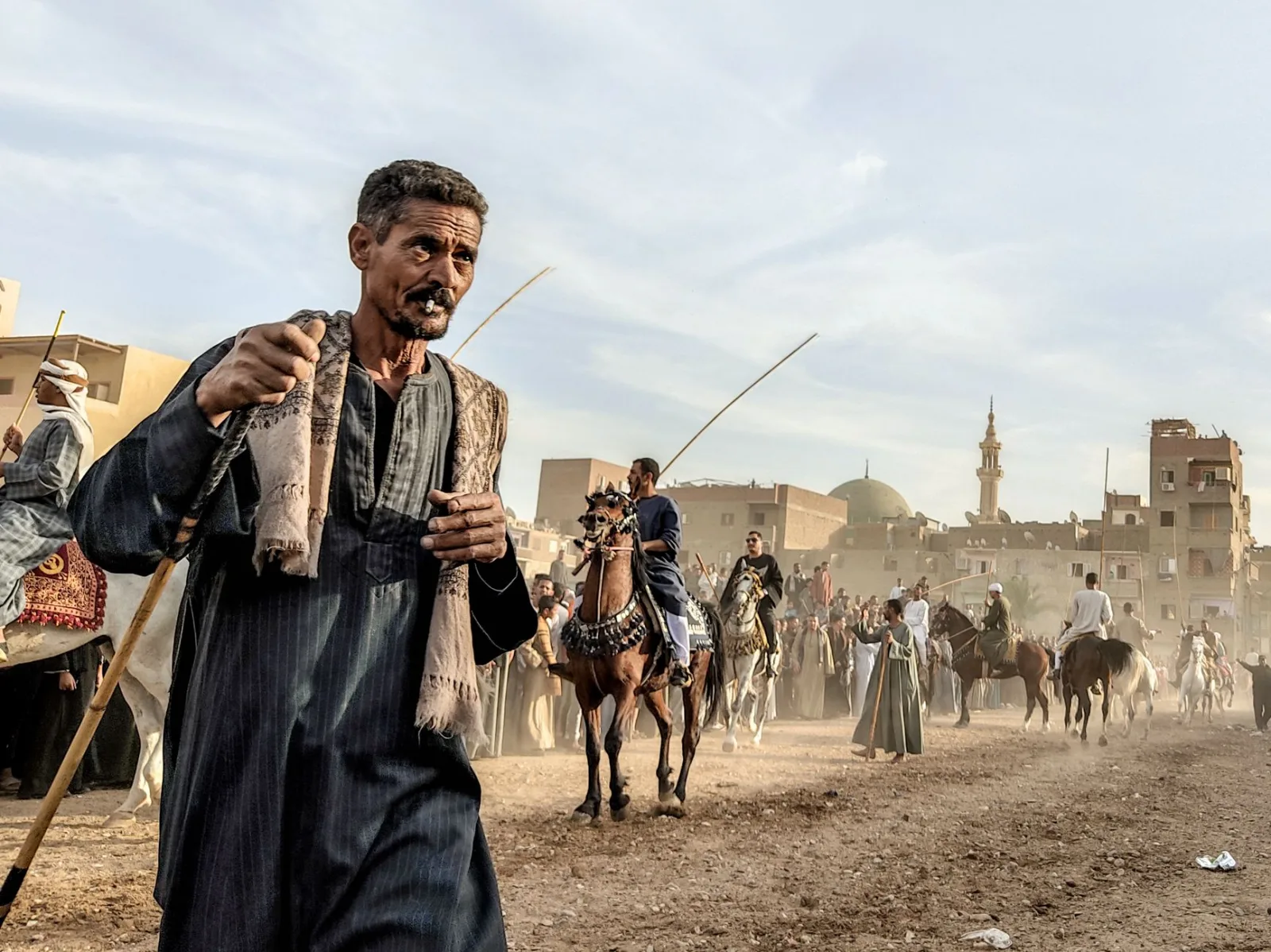 Men and horses at a traditional festival parade in Egypt, showcasing cultural heritage and equestrian skills.