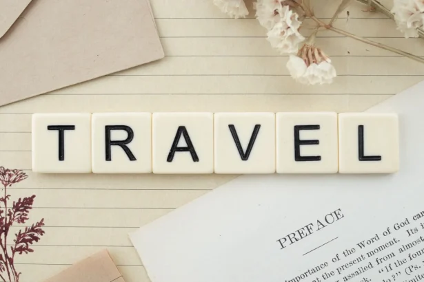 Travel-themed flat lay with Scrabble tiles, dried flowers, and stationery creating a vintage vibe.