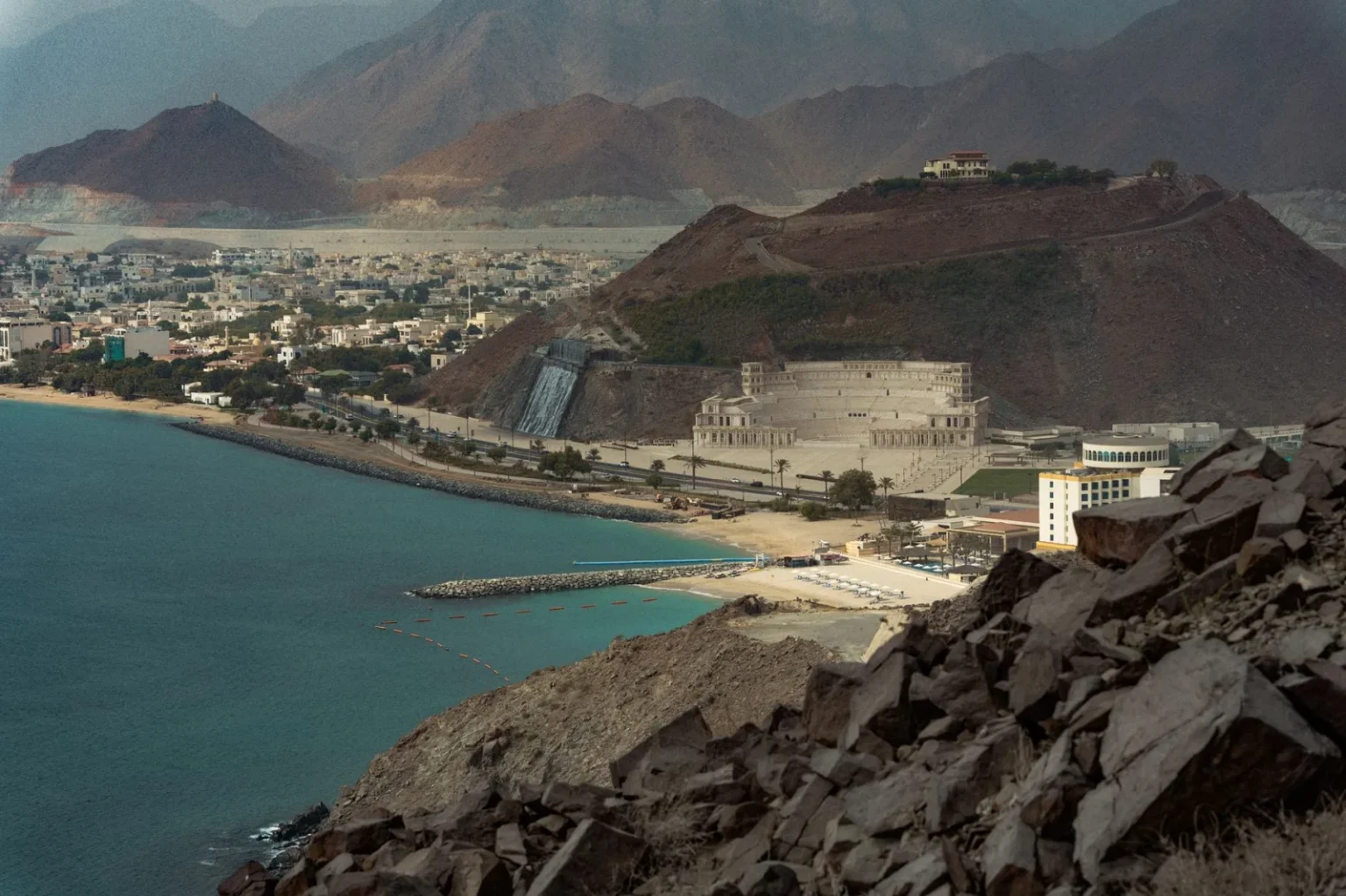 A breathtaking view of Khor Fakkan's coastline with mountains and architecture in Sharjah, UAE.