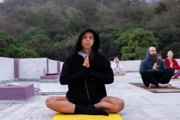 Group meditation session on a rooftop surrounded by nature, focused and calm atmosphere.