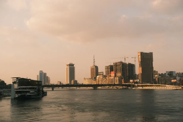 A scenic view of Cairo's skyline along the Nile River at sunset, capturing the city's modern architecture.